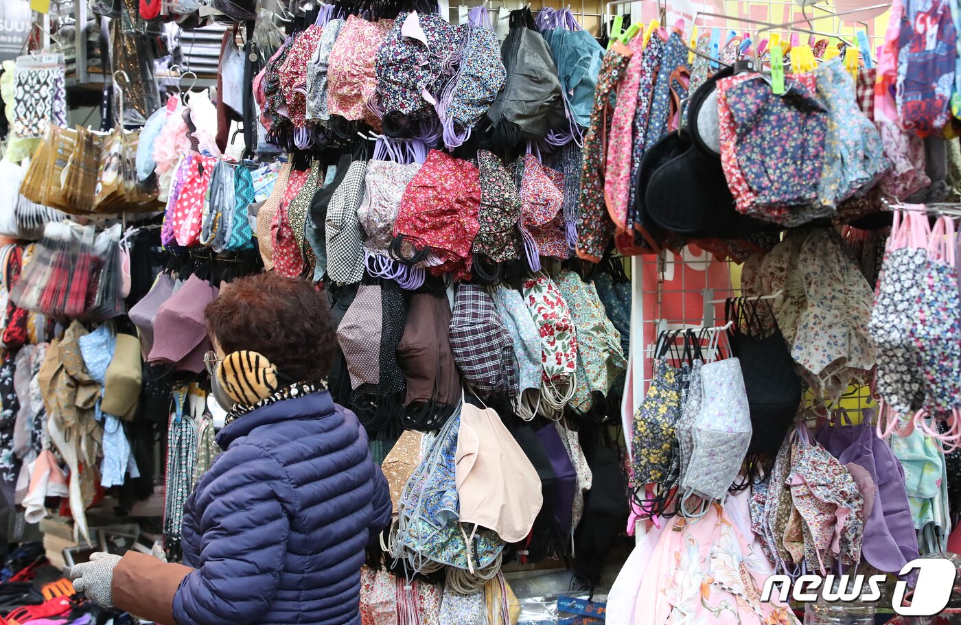 본문 이미지 - 반짝 추위가 찾아온 20일 대구 중구 서문시장 한 마스크 가게 앞에서 상인이 손님을 기다리고 있다. 상인은 "실내 마스크 착용 의무 해제에 따라 마스크 판매도 크게 줄어들고 있다＂고 말했다. 2023.2.20/뉴스1 ⓒ News1 공정식 기자