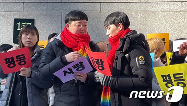 본문 이미지 - 결혼 5년차 동성커플 소성욱 씨와 김용민 씨가 서울 서초구 서울고등법원 앞에서 국민건강보험공단 상대 보험료 부과 취소 처분 소송 항소심 선고 직후 사랑이 적힌 종이를 들고 있다. 2023.2.21/뉴스1 ⓒ News1 구진욱 기자