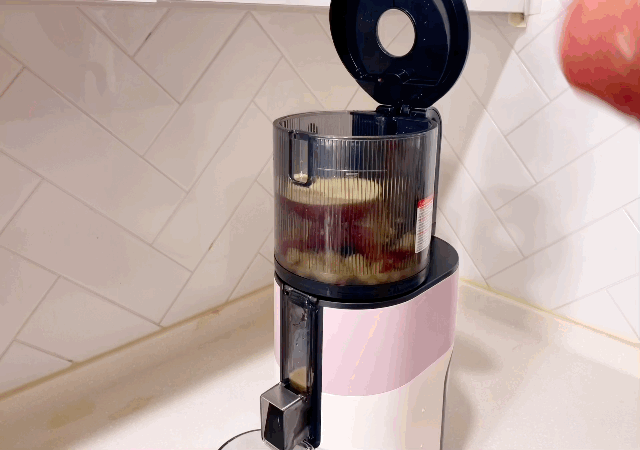 본문 이미지 - 휴롬 H400에 반으로 자른 사과를 넣는 모습. ⓒ News1 이민주 기자