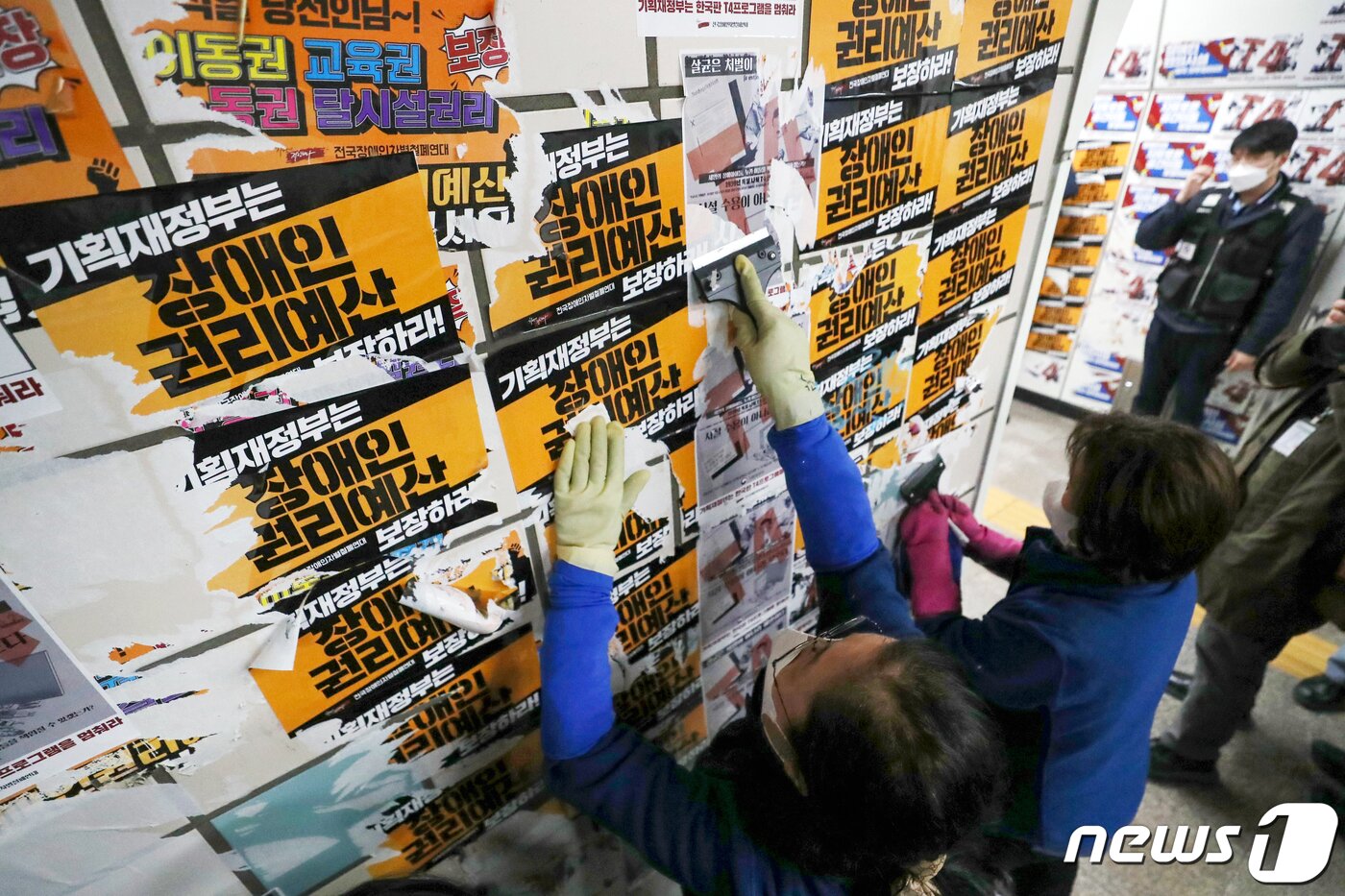 본문 이미지 - 서울교통공사의 자회사 서울메트로환경 미화원들이 27일 오전 용산구 4호선 삼각지역 승강장에서 전국장애인차별철폐연대(전장연)의 출근길 시위 당시 부착한 선전용 스티커를 제거하고 있다. 2023.2.27/뉴스1 ⓒ News1 민경석 기자