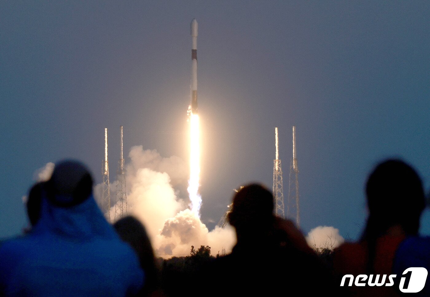 본문 이미지 - 27일 (현지시간) 플로리다주 케이프 커네버럴 우주군 기지의 40번 발사대에서 고도 230마일의 궤도에 배치될 스타링크 V2 미니 위성을 탑재한 민간 우주업체 스페이스 X의 팰콘 9 로켓이 발사되는 모습을 사람들이 지켜 보고 있다. ⓒ AFP=뉴스1 ⓒ News1 우동명 기자