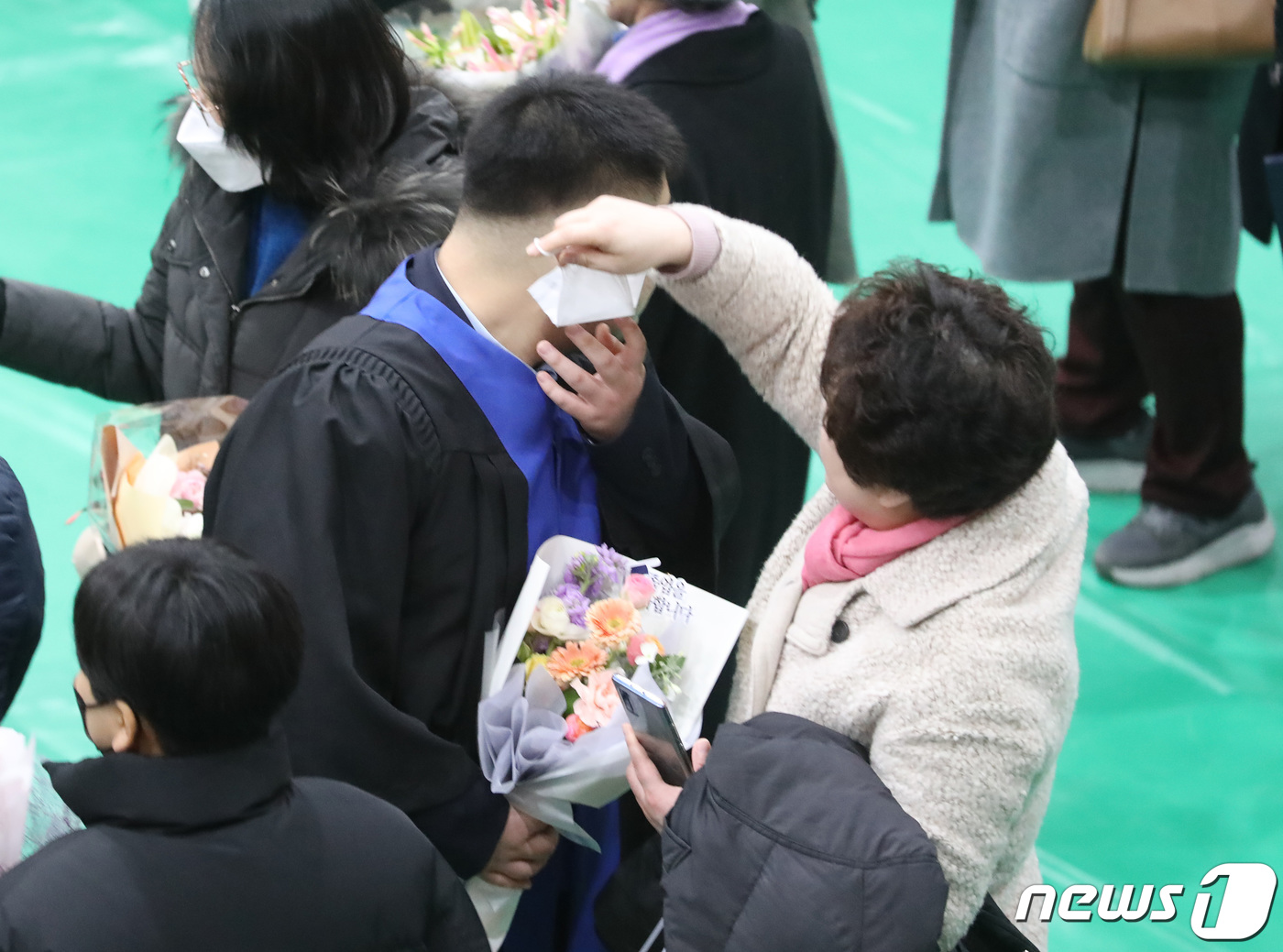 (서울=뉴스1) 김민지 기자 = 3일 오전 제98회 졸업식이 열린 서울 종로구 경복고등학교에서 한 어머니가 아들의 마스크를 벗겨주고 있다. 2023.2.3/뉴스1