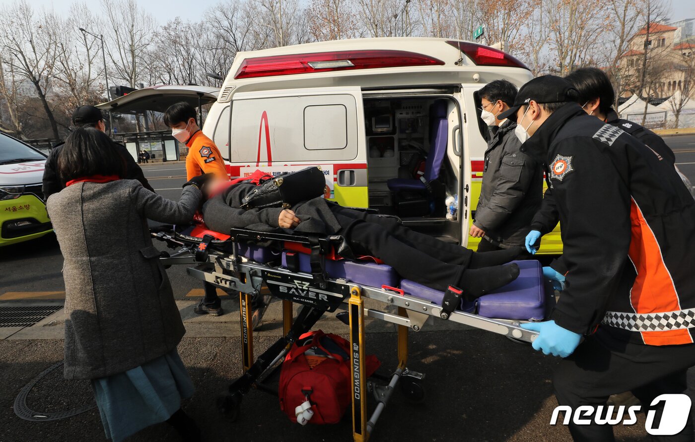 본문 이미지 - 이태원 참사 희생자 유가족이 6일 오전 서울시청 앞에 마련된 시민분향소에 난로를 들이다가 경찰 인력과 충돌 후 구급대원에 의해 이송되고 있다.  2023.2.6/뉴스1 ⓒ News1 이동해 기자