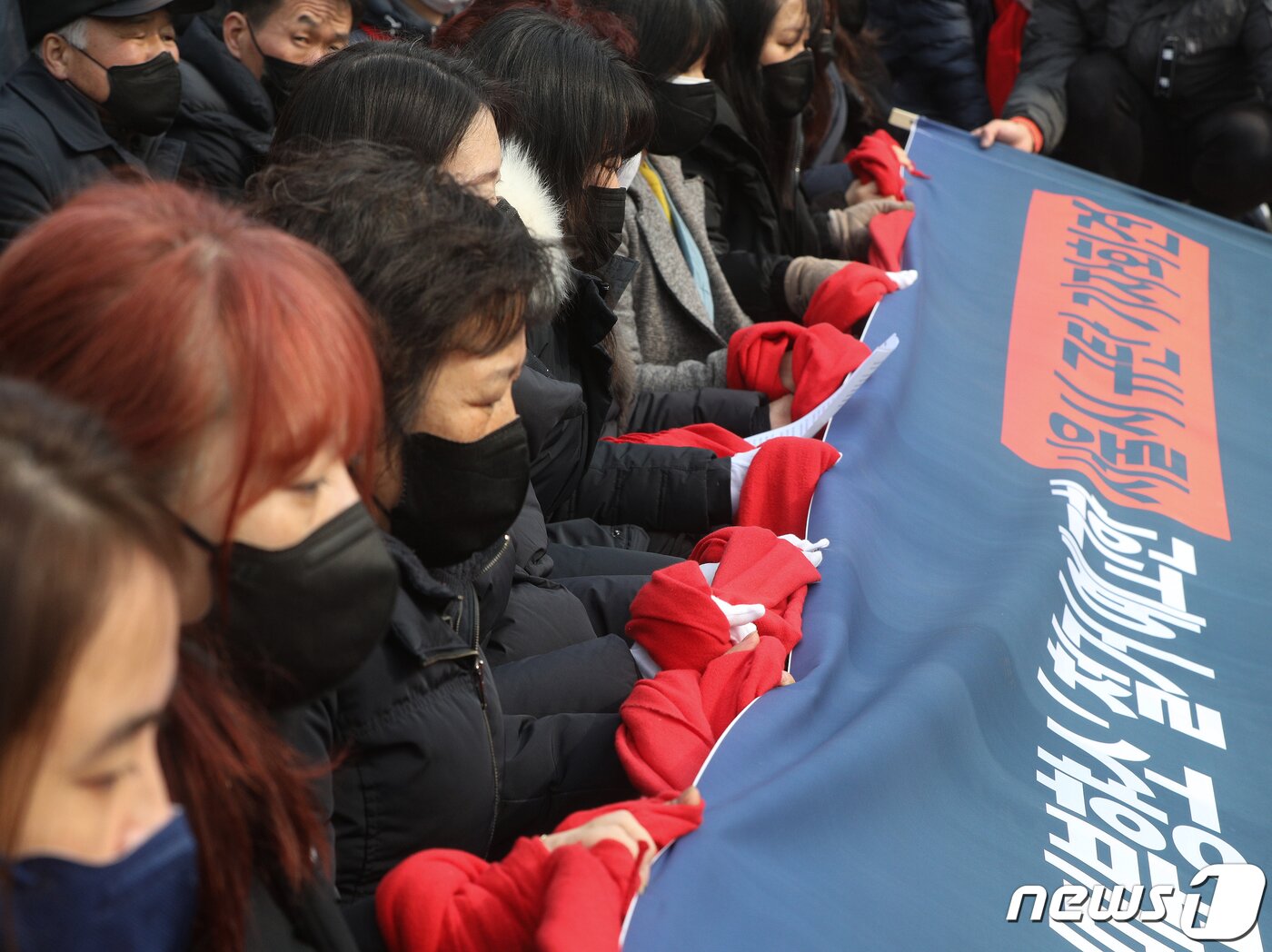 본문 이미지 - 이태원 참사 유가족협의회 회원들이 6일 오후 서울시청 앞에 마련된 이태원 참사 희생자 시민분향소에서 가진 기자회견에서 붉은 목도리로 손을 묶고 있다. 2023.2.6/뉴스1 ⓒ News1 신웅수 기자