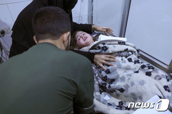 6일(현지시간) 시리아 잔다리스 마을에서 구조된 한 어린 아이가 병원 침상에 누워 구조 대원을 바라보고 있다. 이날 새벽 사람들이 잠든 사이 시리아를 강타한 지진으로 현장에서는 정확한 사망자 수를 집계할 수 없을 정도로 큰 인명피해가 발생했다. © AFP=뉴스1 © News1 권진영 기자