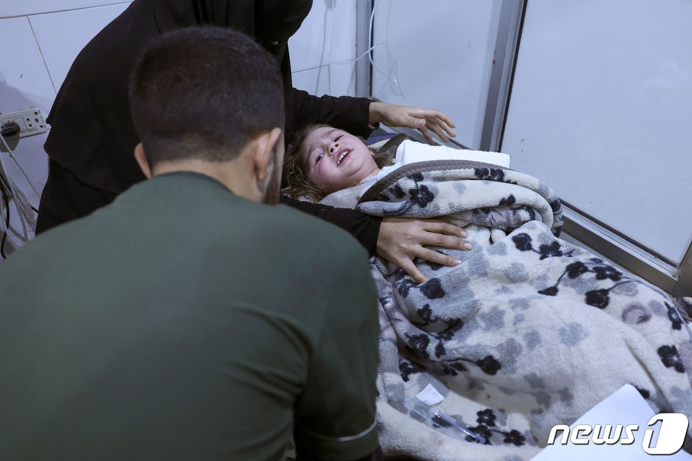 6일&#40;현지시간&#41; 시리아 잔다리스 마을에서 구조된 한 어린 아이가 병원 침상에 누워 구조 대원을 바라보고 있다. 이날 새벽 사람들이 잠든 사이 시리아를 강타한 지진으로 현장에서는 정확한 사망자 수를 집계할 수 없을 정도로 큰 인명피해가 발생했다. ⓒ AFP=뉴스1 ⓒ News1 권진영 기자