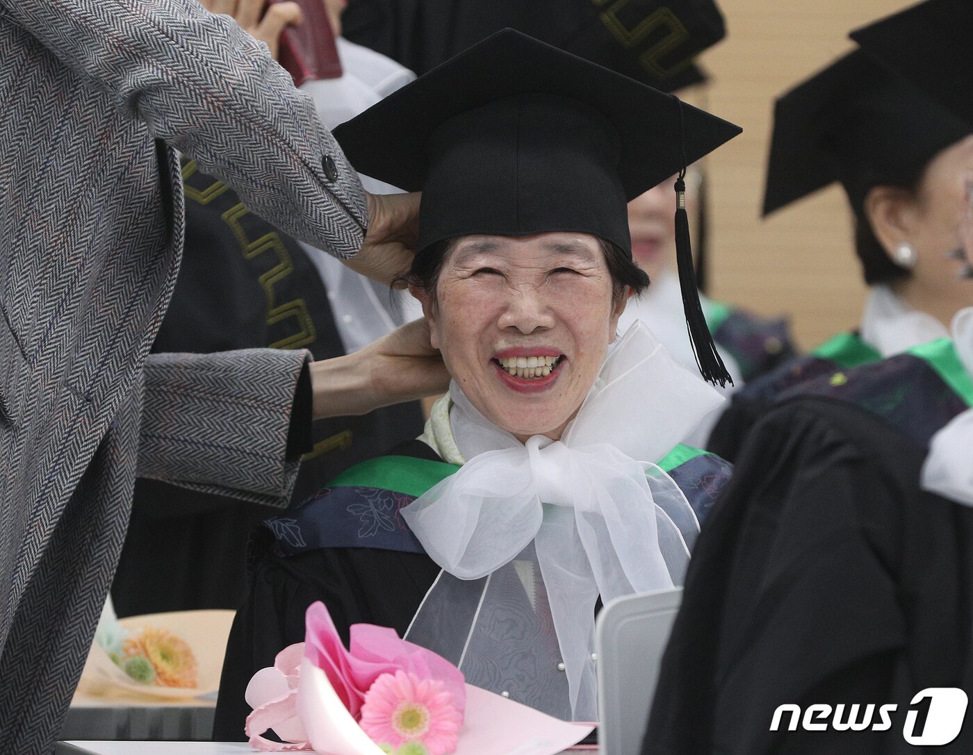 본문 이미지 - 8일 서울 영등포구청 별관에서 열린 늘푸름학교 졸업식에서 한 졸업생이 학사모를 고쳐쓰며 미소짓고 있다. 2023.2.8/뉴스1 ⓒ News1 신웅수 기자