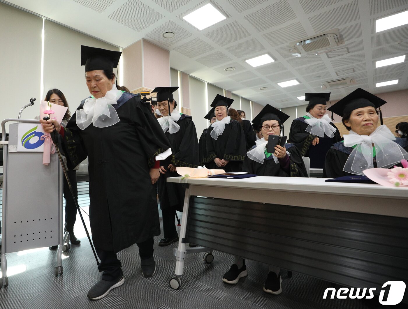 본문 이미지 - 8일 서울 영등포구청 별관에서 열린 늘푸름학교 졸업식에서 한 졸업생이 졸업장을 받기 위해 지팡이를 들고 단상으로 향하고 있다. 2023.2.8/뉴스1 ⓒ News1 신웅수 기자