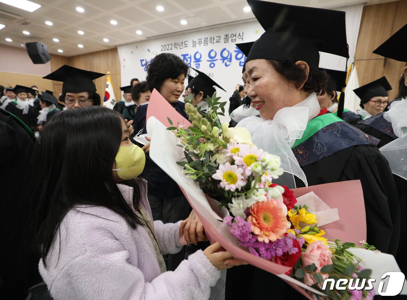 본문 이미지 - 8일 서울 영등포구청 별관에서 열린 늘푸름학교 졸업식에서 졸업생이 손녀로부터 꽃다발을 받고 있다. 2023.2.8/뉴스1 ⓒ News1 신웅수 기자