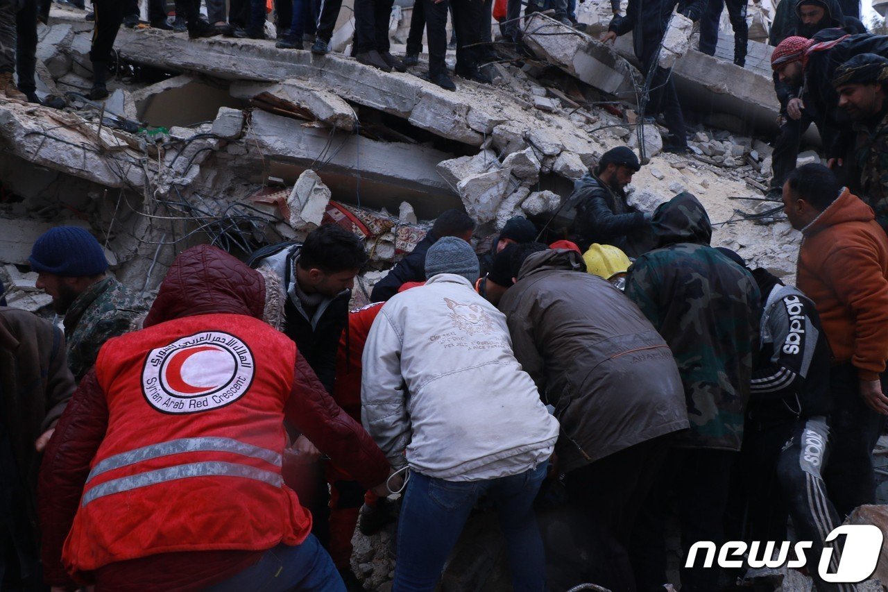 본문 이미지 - 지난 6일 튀르키예 동남부에서 발생한 대형 지진으로 피해를 입은 시리아에서 시리아적신월사 직원과 봉사원들이 구호활동을 펼치고 있다. (시리아적신월사 제공) 2023.2.8/뉴스1