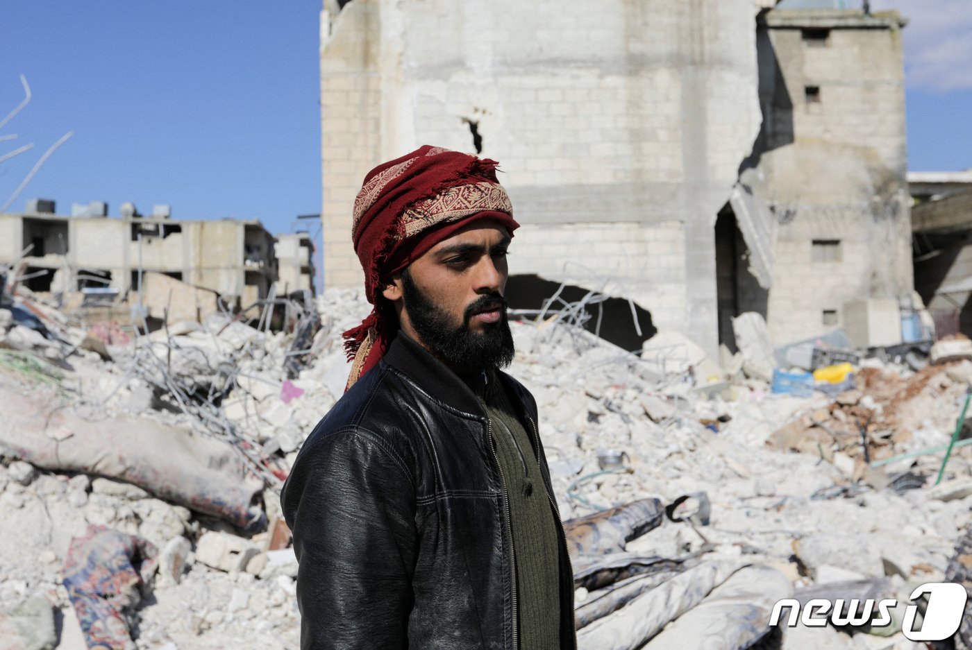 본문 이미지 - 8일(현지시간) 시리아 잔다리스 마을에서 매형과 조카를 구한 살라 알하지 알 아캅이 잔해더미를 바라보고 있다. 그는 대지진으로 누나와 어린 조카를 잃었다. ⓒ 로이터=뉴스1 ⓒ News1 권진영 기자