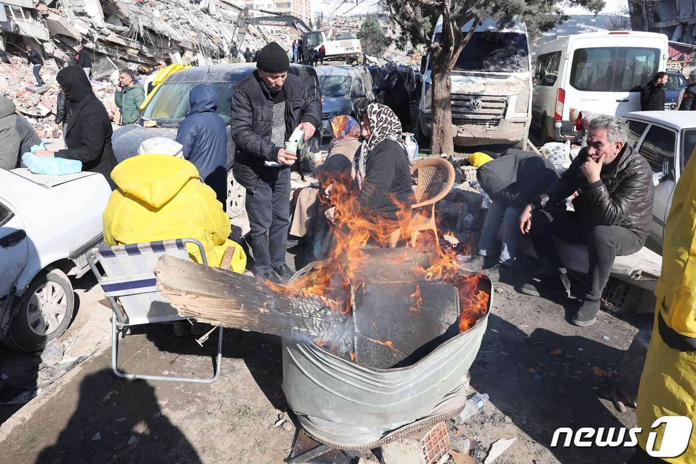 7일&#40;현지시간&#41; 튀르키예 카흐라만마라슈에서 구조대원과 사람들이 모닥불 옆에서 몸을 녹이고 있다. 설상가상으로 내린 눈이 잔해 위에 쌓여 구조작업을 더 어렵게 만들고 있다. ⓒ AFP=뉴스1 ⓒ News1 권진영 기자