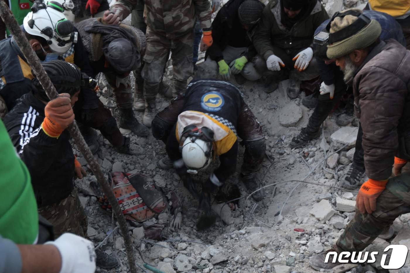 본문 이미지 - 규모 7.8 강진 발생 사흘째인 8일(현지시간) 시리아 북서부 반군 점령지역 진디레스에서 한 구조대원이 무너진 건물 잔해에 깔린 어린아이들을 구조하기 위해 콘크리트 더미를 헤치고 있다. 2023.2.8. ⓒ AFP=뉴스1 ⓒ News1 김성식 기자