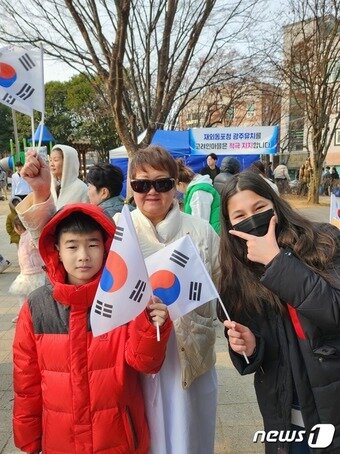 본문 이미지 - 광주 광산구 월곡동 고려인마을에서 고 엘리나 양(오른쪽)과 할머니 고 릴리야씨(가운데)가 태극기를 흔들고 있다. 한국에 온 지 7년째인 고양은 "한국 역사에 관심이 많다. 다들 한국 역사와 문화를 더 소중히 했으면 좋겠다”고 말했다.2023.3.1./뉴스1