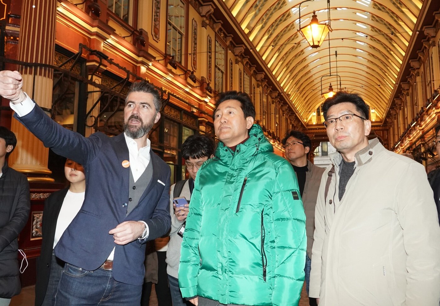 본문 이미지 - 오세훈 시장이 13일(현지시간) 런던 리덴홀 마켓에서 로저스 스터크 하버+파트너스(RSHP) 관계자로부터 주변 건물에 대한 설명을 듣고 있다. 왼쪽부터 존 맥엘건 RSHP 파트너, 오세훈 서울시장, 조남준 서울시 도시계획국장. (서울시 제공)