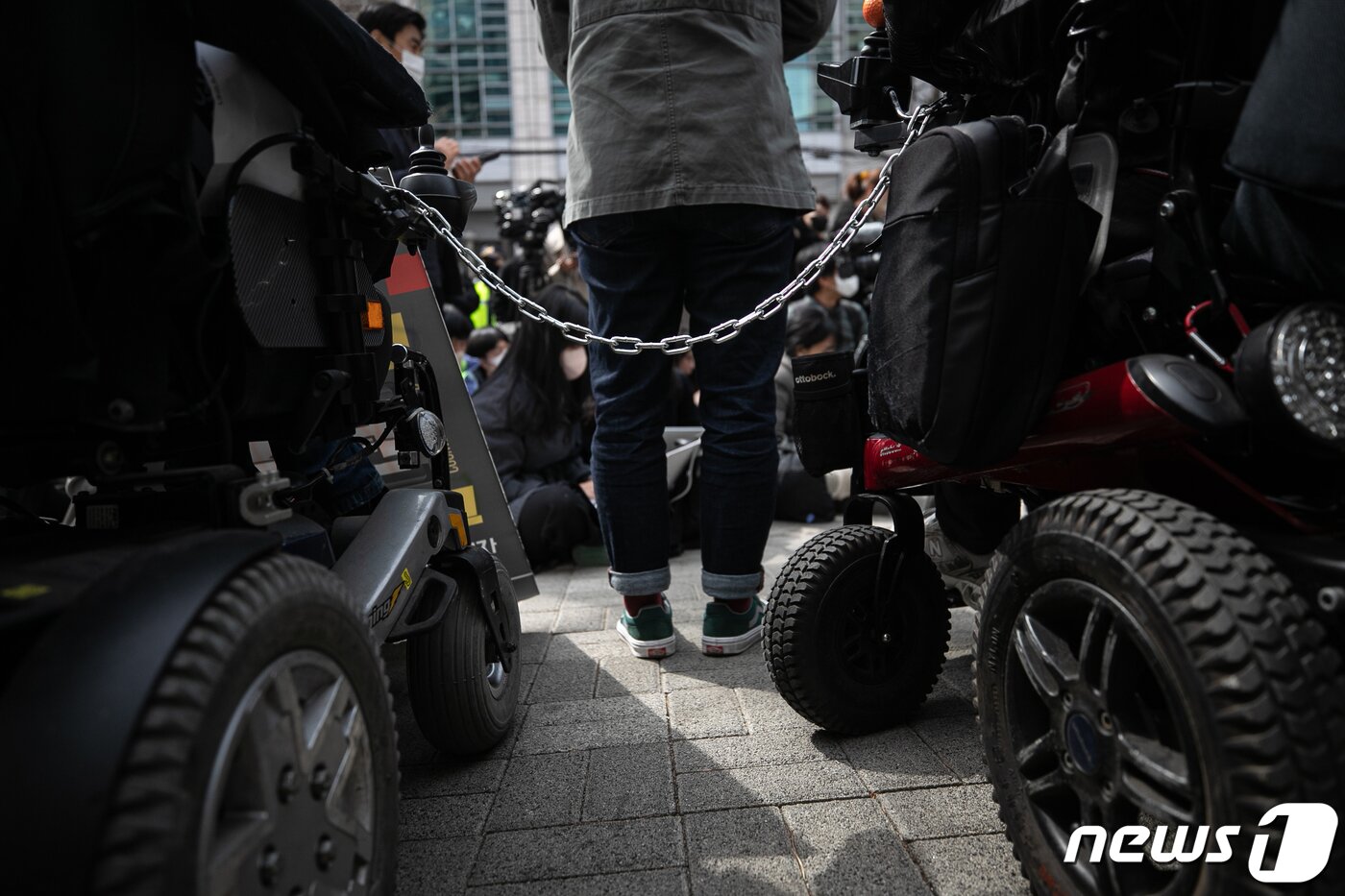 본문 이미지 - 17일 오전 서울 종로구 서울지방경찰청 앞에서 열린 박경석 전국장애인차별철폐연대(전장연) 대표 법원의 체포영장 발부에 따른 입장발표 기자회견에서 참가자들이 쇠사슬로 서로를 잇고 있다. 2023.3.17/뉴스1 ⓒ News1 이승배 기자