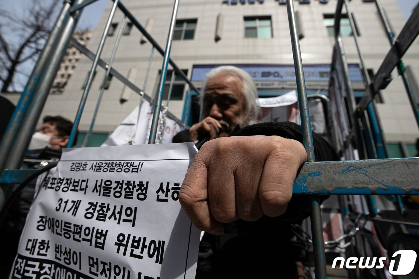 본문 이미지 - 박경석 전국장애인차별철폐연대(전장연) 대표가 17일 오전 서울 종로구 서울지방경찰청 앞에서 몸에 쇠사슬을 두르고 철창 속에서 법원의 체포영장 발부에 따른 입장발표 기자회견을 하고 있다. 2023.3.17/뉴스1 ⓒ News1 이승배 기자