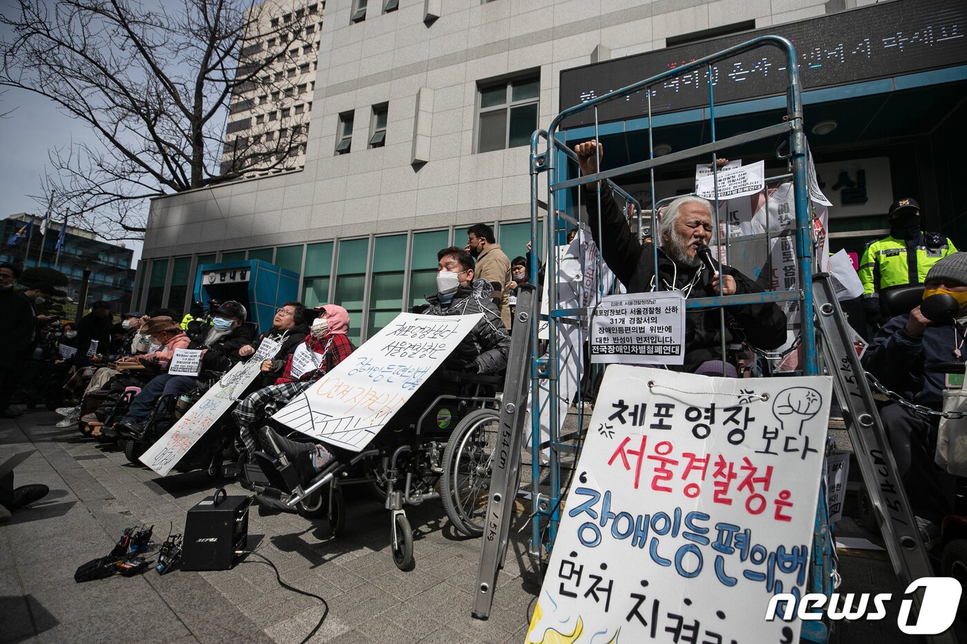 본문 이미지 - 박경석 전국장애인차별철폐연대(전장연) 대표가 17일 오전 서울 종로구 서울지방경찰청 앞에서 몸에 쇠사슬을 두르고 철창 속에서 법원의 체포영장 발부에 따른 입장발표 기자회견을 하고 있다.  2023.3.17/뉴스1 ⓒ News1 이승배 기자
