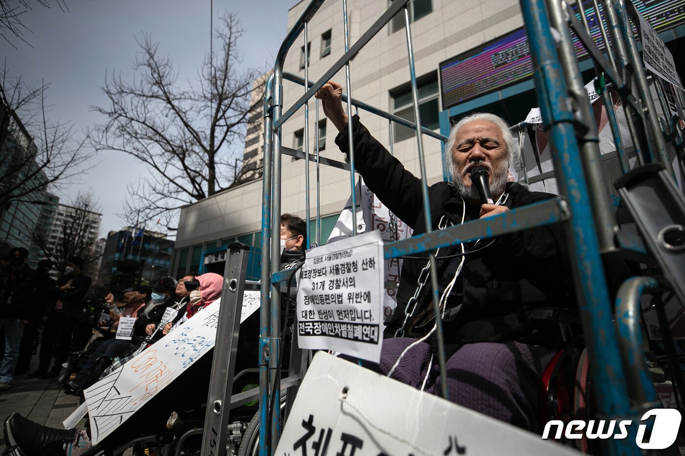 본문 이미지 - 박경석 전국장애인차별철폐연대(전장연) 대표가 17일 오전 서울 종로구 서울지방경찰청 앞에서 몸에 쇠사슬을 두르고 철창 속에서 법원의 체포영장 발부에 따른 입장발표 기자회견을 하고 있다.  2023.3.17/뉴스1 ⓒ News1 이승배 기자