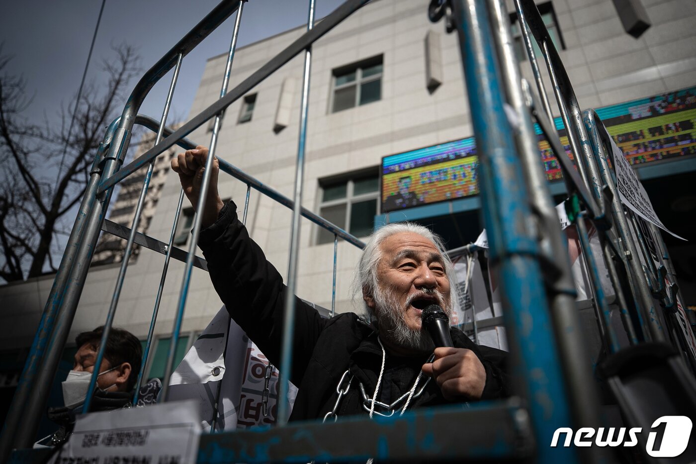 본문 이미지 - 박경석 전국장애인차별철폐연대(전장연) 대표가 17일 오전 서울 종로구 서울지방경찰청 앞에서 몸에 쇠사슬을 두르고 철창 속에서 법원의 체포영장 발부에 따른 입장발표 기자회견을 하고 있다.  2023.3.17/뉴스1 ⓒ News1 이승배 기자