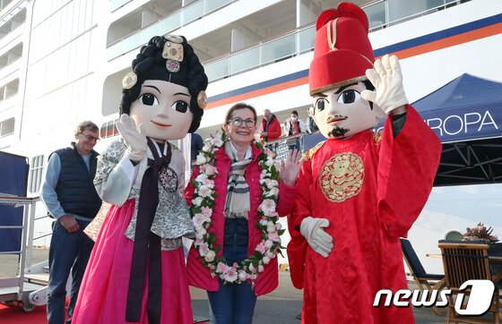 본문 이미지 - MS Europa2호에서 내린 첫 관광객이 19일 오전 인천항 내항에 들어온 후 인천시 관계자에게 꽃목걸이를 받은 후 기념사진을 촬영하고 있다. 크루즈선 인천항 입항은 코로나19로 멈춘 후 3년만이다. MS Europa2호에 승선한 관광객 544명은 이날 한국 관광을 한 뒤 일본으로 떠날 예정이다. 2023.3.19/뉴스1 ⓒ News1 정진욱 기자