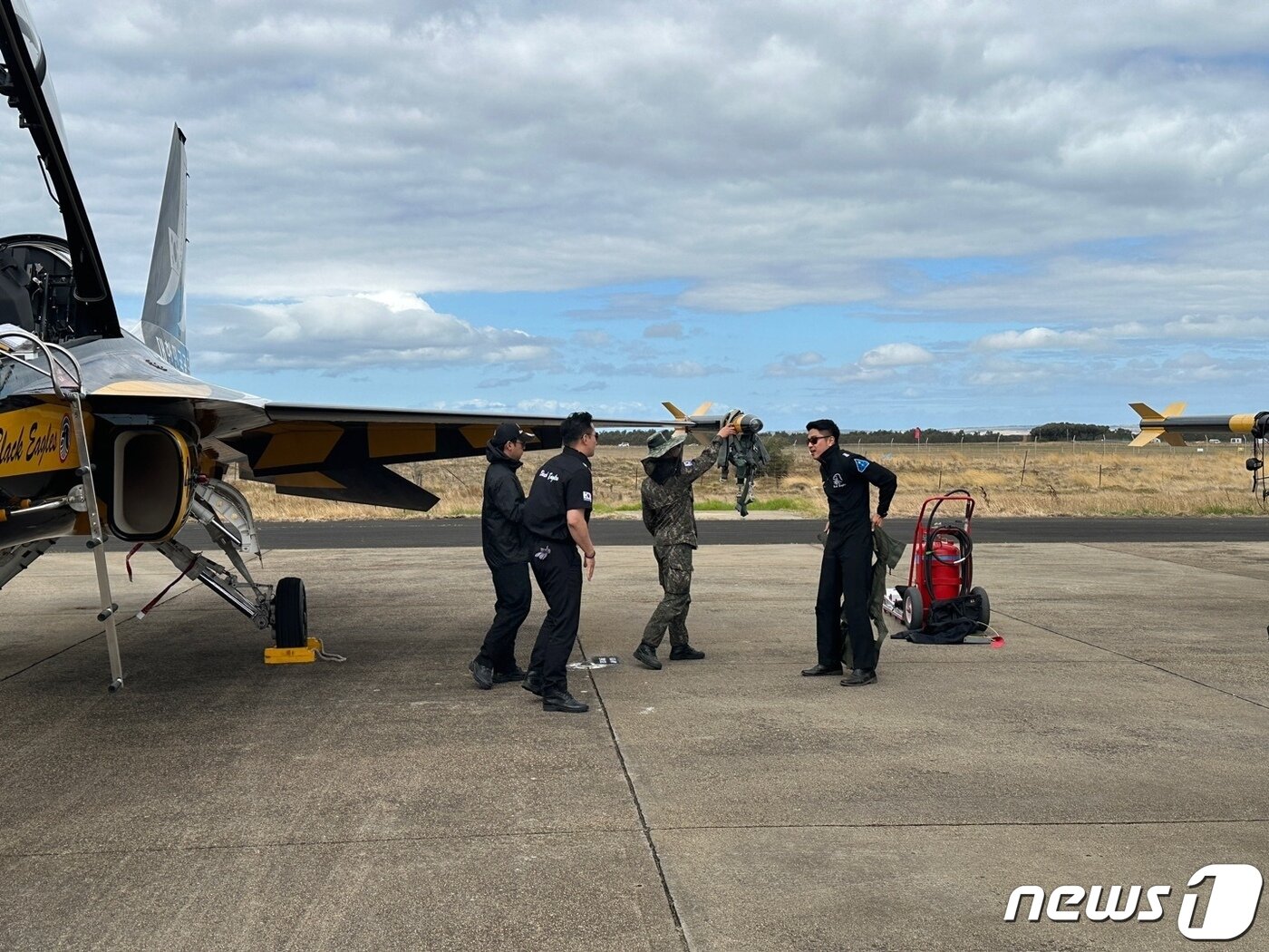 본문 이미지 - 공군 특수비행팀 '블랙이글스' 4호기 조종사 김기혁 대위(오른쪽)가 1일(현지시간) 호주 애벌론 에어쇼 현장에서 조종복을 입으며 T-50 탑승을 준비하고 있다. ⓒ News1 이창규 기자