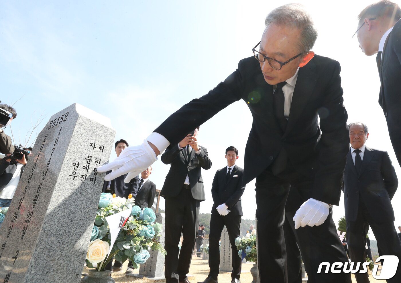 본문 이미지 - 이명박 전 대통령이 서해수호의 날을 앞두고 22일 대전 유성구 국립대전현충원을 찾아 천안함 46용사 묘역에 참배한 뒤 묘비를 어루만지고 있다. 2023.3.22/뉴스1 ⓒ News1 김기태 기자