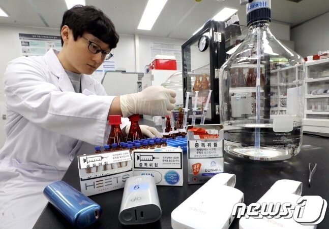 본문 이미지 - 식품의약품안전처 연구원이 궐련형 전자담배의 배출물 포집 및 추출 과정을 시연하고 있다. 2018.6.7/뉴스1 ⓒ News1 장수영 기자