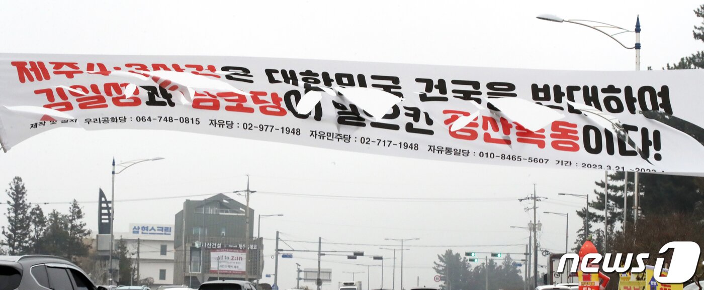 본문 이미지 - 23일 오후 제주시 오라이동 거리에 보수정당 등이 설치한 '제주4·3 사건은 대한민국 건국을 반대하여 김일성과 남로당이 일으킨 공산폭동이다'라는 문구가 담긴 현수막이 찢겨 있다. 2023.3.23/뉴스1 ⓒ News1 오현지 기자