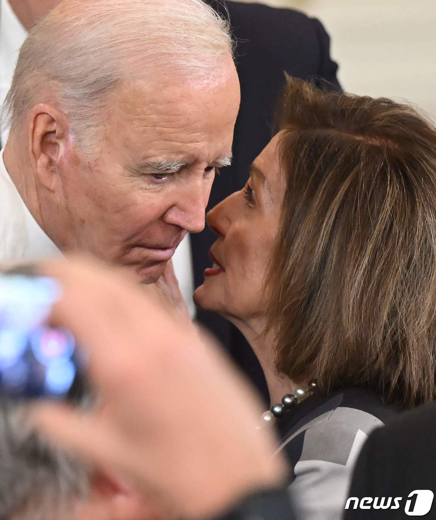 본문 이미지 - 조 바이든 미국 대통령과 낸시 펠로시 전 하원의장이 지난 3월 23일(현지시간) 워싱턴 백악관에서 열린 오바마 케어 법안 제정 13주년 기념식서 귓속말에 가까운 대화를 하고 있다. ⓒ AFP=뉴스1 ⓒ News1 우동명 기자