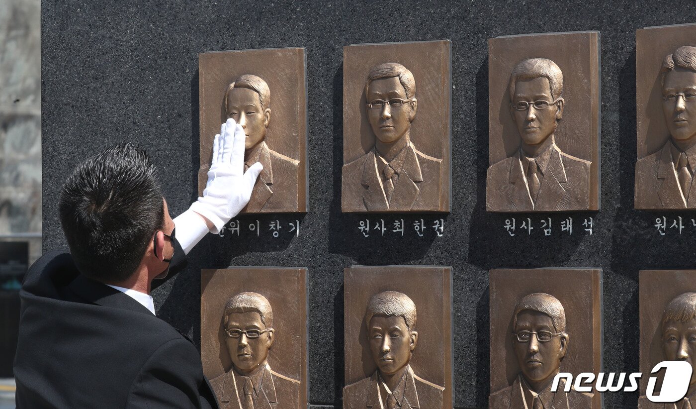 본문 이미지 - 26일 오전 경기 평택시 해군 제2함대사령부에서 열린 '제13주기 천안함 46용사 추모식'에서 유가족들이 천안함 46용사 부조물을 어루만지고 있다. 2023.3.26/뉴스1 ⓒ News1 김영운 기자