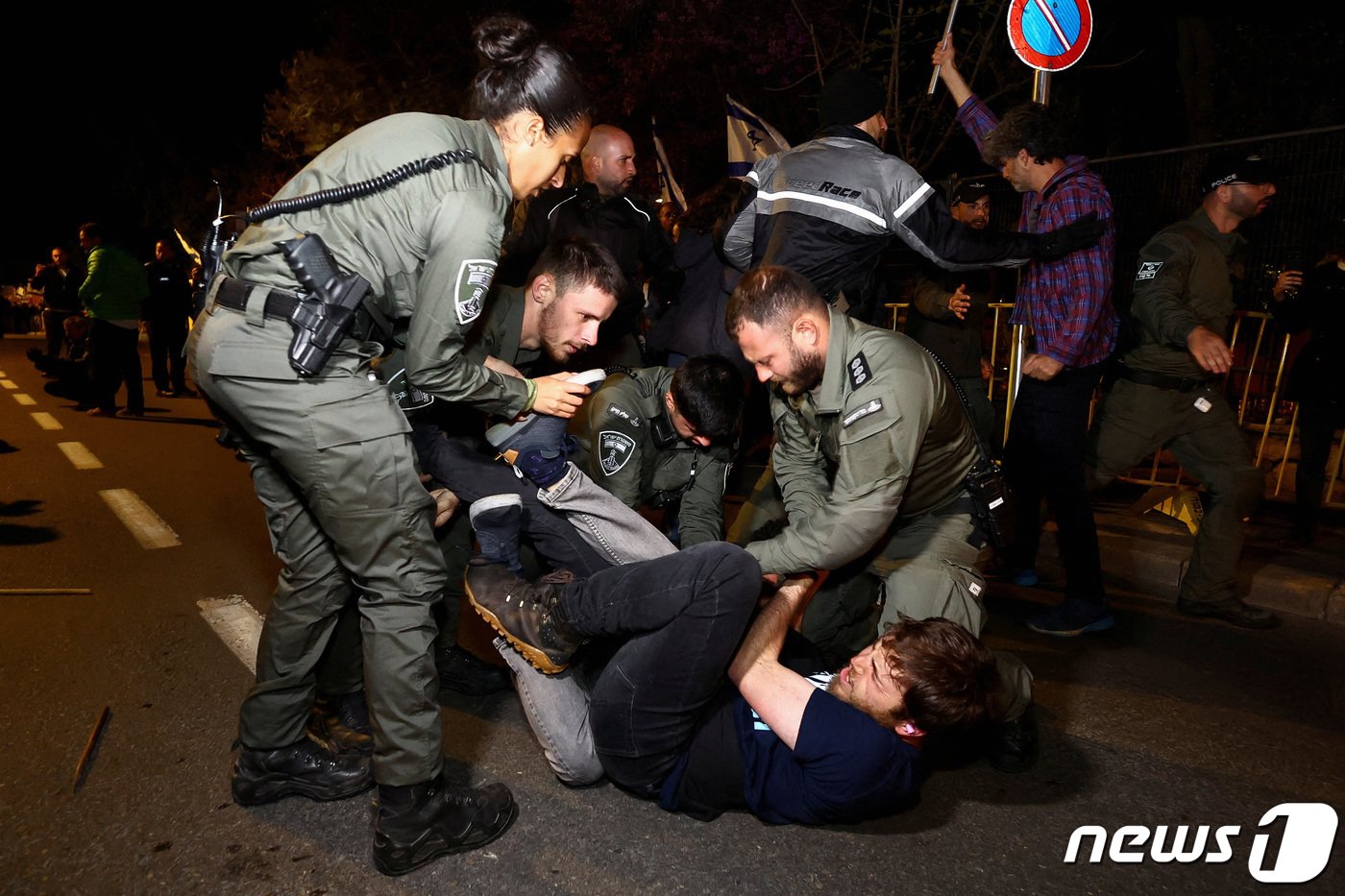 본문 이미지 - 26일(현지시간) 이스라엘 예루살렘에서 베냐민 네타냐후 이스라엘 총리의 사법부 무력화 입법안에 반대하는 시위가 벌어진 가운데 경찰이 시위대를 체포하고 있다. 23.03.26 ⓒ 로이터=뉴스1 ⓒ News1 김예슬 기자