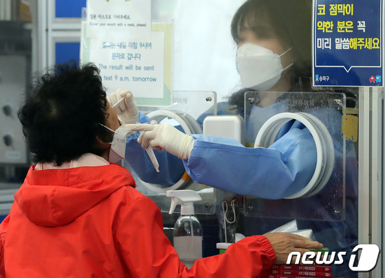 서울 송파구 보건소에서 한 시민이 PCR검사를 받고 있는 모습./뉴스1 © News1 김진환 기자