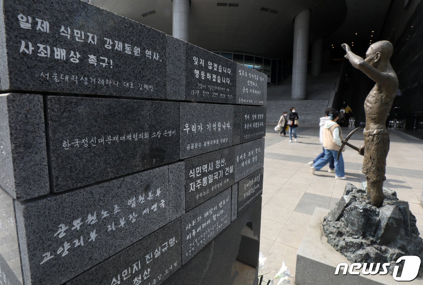 일본 초등학생이 내년도부터 사용할 사회 교과서에서 일제강점기 조선인 징병에 관한 기술이 강제성을 희석하는 방향으로 변경 발표된 28일 서울 용산구 용산역광장에 자리한 강제징용노동자상 앞으로 시민이 지나고 있다.  2023.3.28/뉴스1 ⓒ News1 이동해 기자