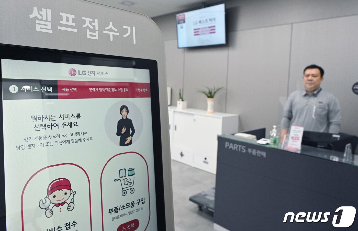 본문 이미지 - 서울 광진구 LG전자 광진서비스센터에 설치된 키오스크에서 서비스엔지니어가 디지털휴먼의 수어 안내를 받아 서비스를 접수하는 방법을 안내하고 있다.(LG전자 제공) 2023.3.3/뉴스1