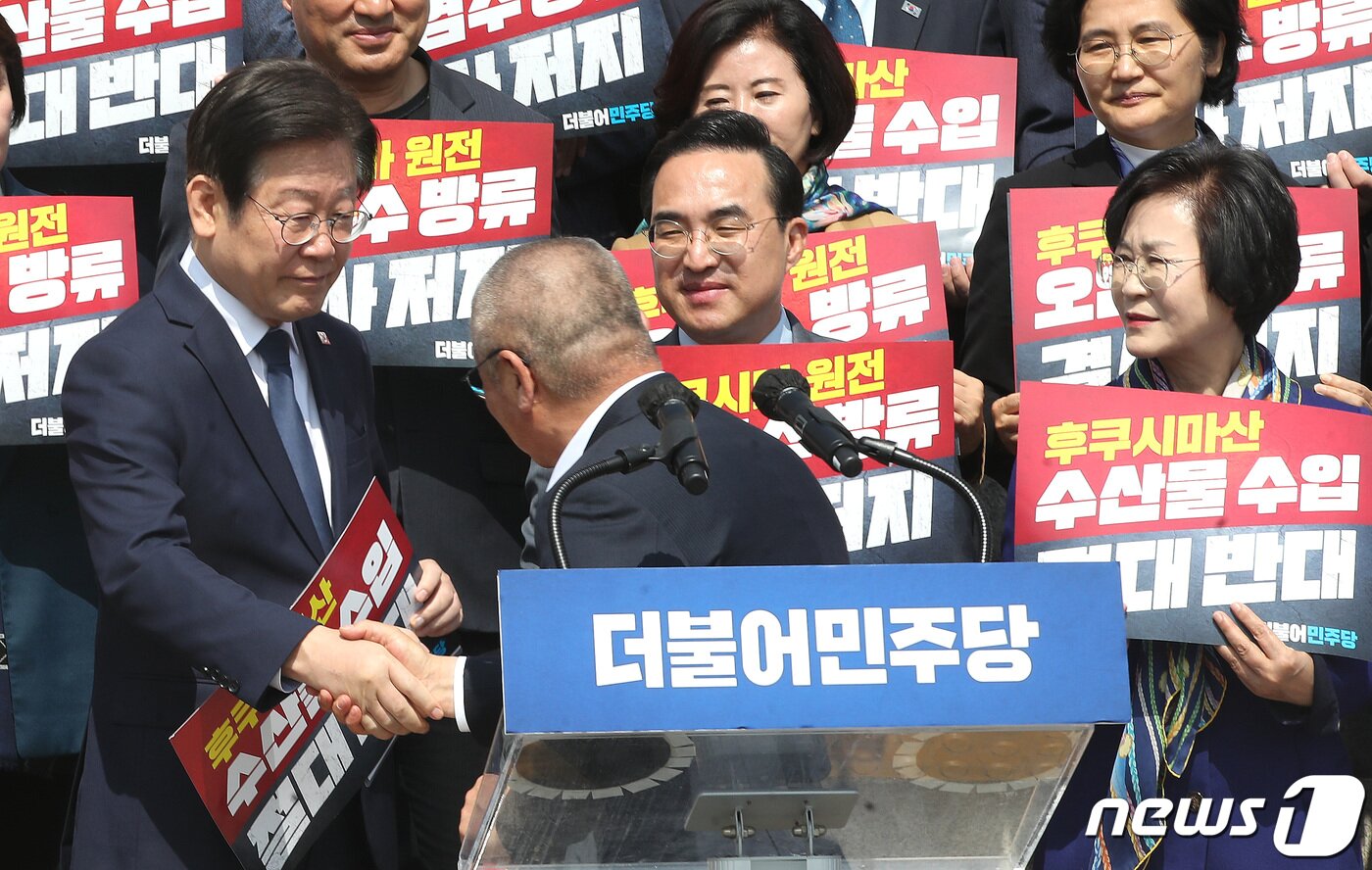 본문 이미지 - 이재명 더불어민주당 대표가 30일 오전 서울 영등포구 여의도 국회 본관 앞 계단에서 열린 후쿠시마산 수산물 수입 반대 및 대일 굴욕외교 규탄대회에서 삭발식에 나선 윤재갑 의원과 악수를 나누고 있다. 2023.3.30/뉴스1 ⓒ News1 임세영 기자