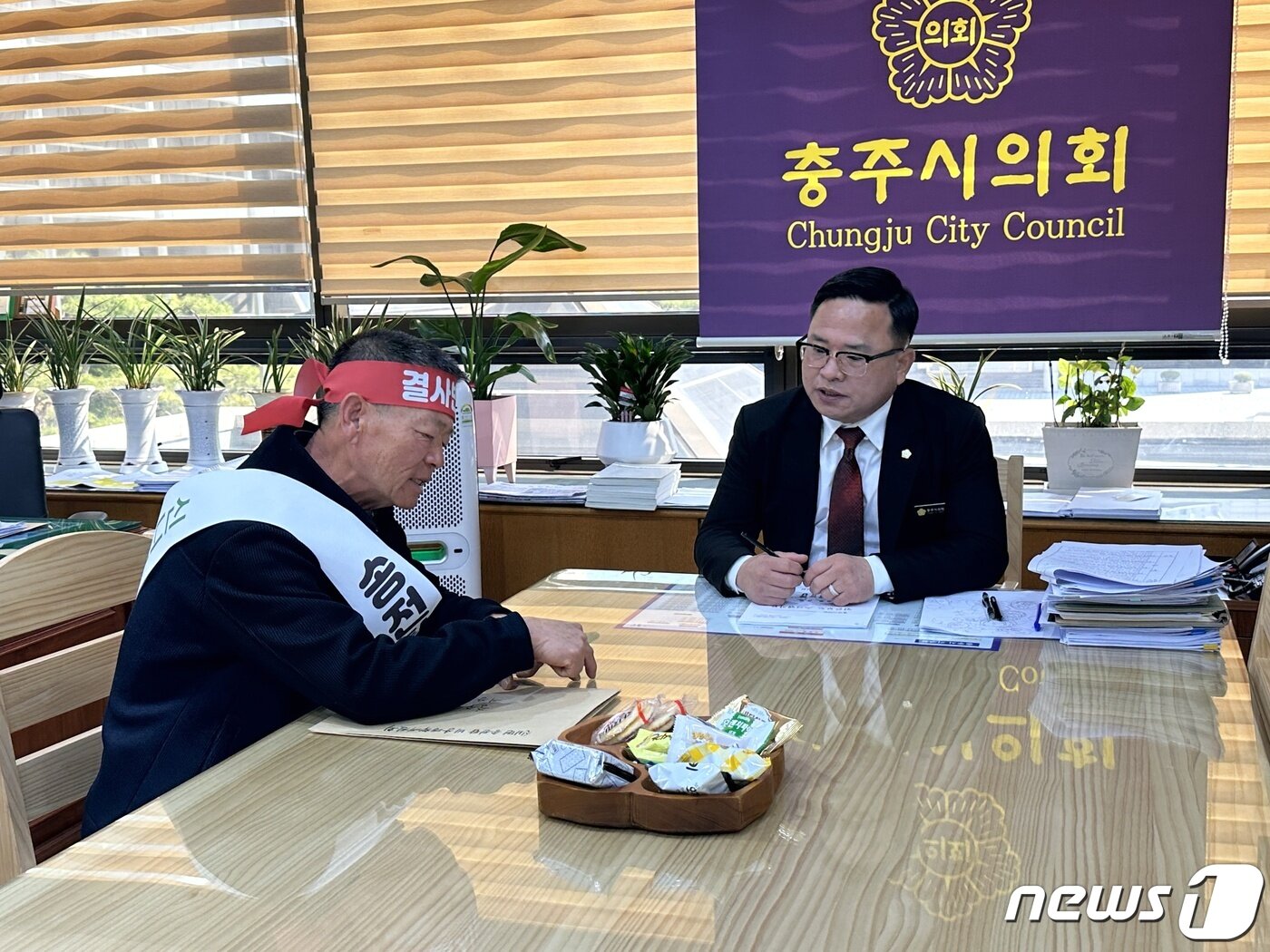 본문 이미지 - 30일 지용식 신니면 송전탑 설치 반대 비상대책위원장이 박해수 충주시의회 의장을 만나 주민 건의안을 전달하고 있다.2023.3.30/뉴스1