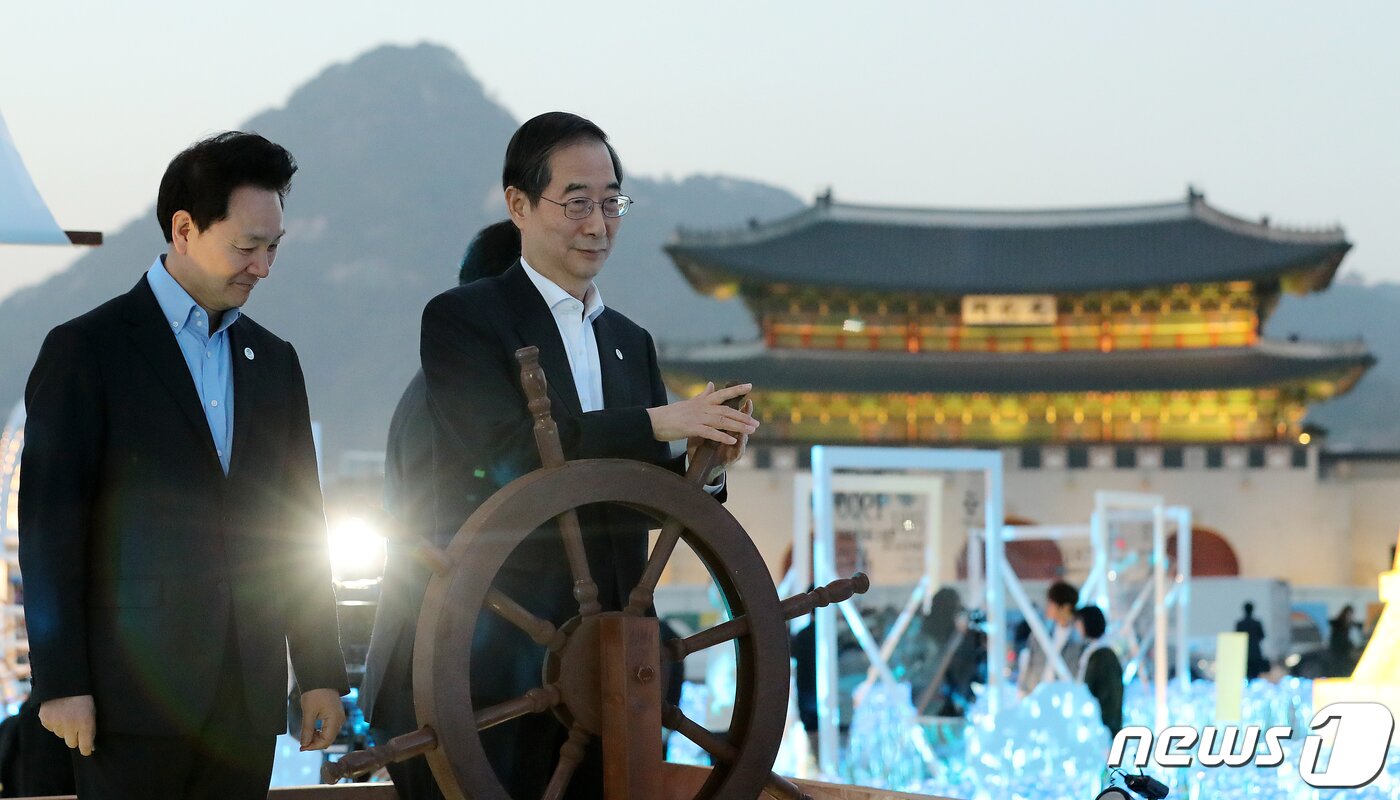본문 이미지 - 한덕수 국무총리가 30일 오후 서울 종로구 광화문 광장에 마련된 2030 부산세계박람회(EXPO) 유치 기원 점등식에서 조타 핸들을 돌리고 있다. 2023.3.30/뉴스1 ⓒ News1 김진환 기자