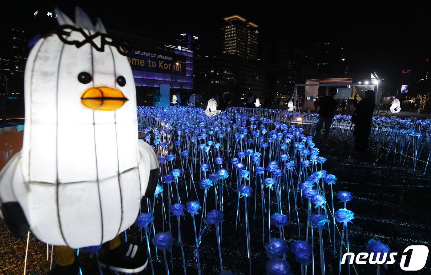본문 이미지 - 30일 오후 서울 종로구 광화문광장에서 열린 '광화에서 빛; 나이다'를 찾은 시민들이 불 밝힌 LED 장미를 살펴보고 있다. 이번 행사는 세계 3대 메가이벤트인 월드엑스포 유치 한국 실사를 앞두고 대한민국 국민들의 엑스포 유치 열망을 국내외에 알리기 위해 마련됐다. 행사 타이틀인 ‘광화에서 빛;나이다’는 역대 엑스포 상징물들을 빛나는 조형물로 구현하여 보여준다는 의미와 2030세계박람회 부산 유치를 기원하는 ‘비나이다’라는 중의적 의미를 담고 있다. 2023.3.30/뉴스1 ⓒ News1 김진환 기자