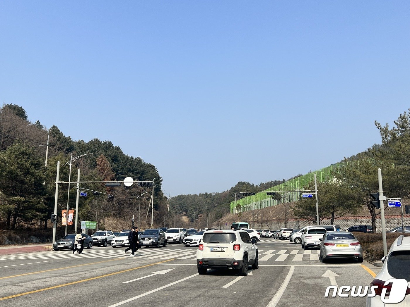 본문 이미지 - 지난 5일 강원 춘천 송암스포츠타운 일대 삼거리 점멸신호등 앞에서 시민들이 횡단도보가 있으나, 신호등이 켜져 있지 않아 시민들이 종종 걸음으로 경기장으로 향하고 있다.2023.3.6 한귀섭 기자