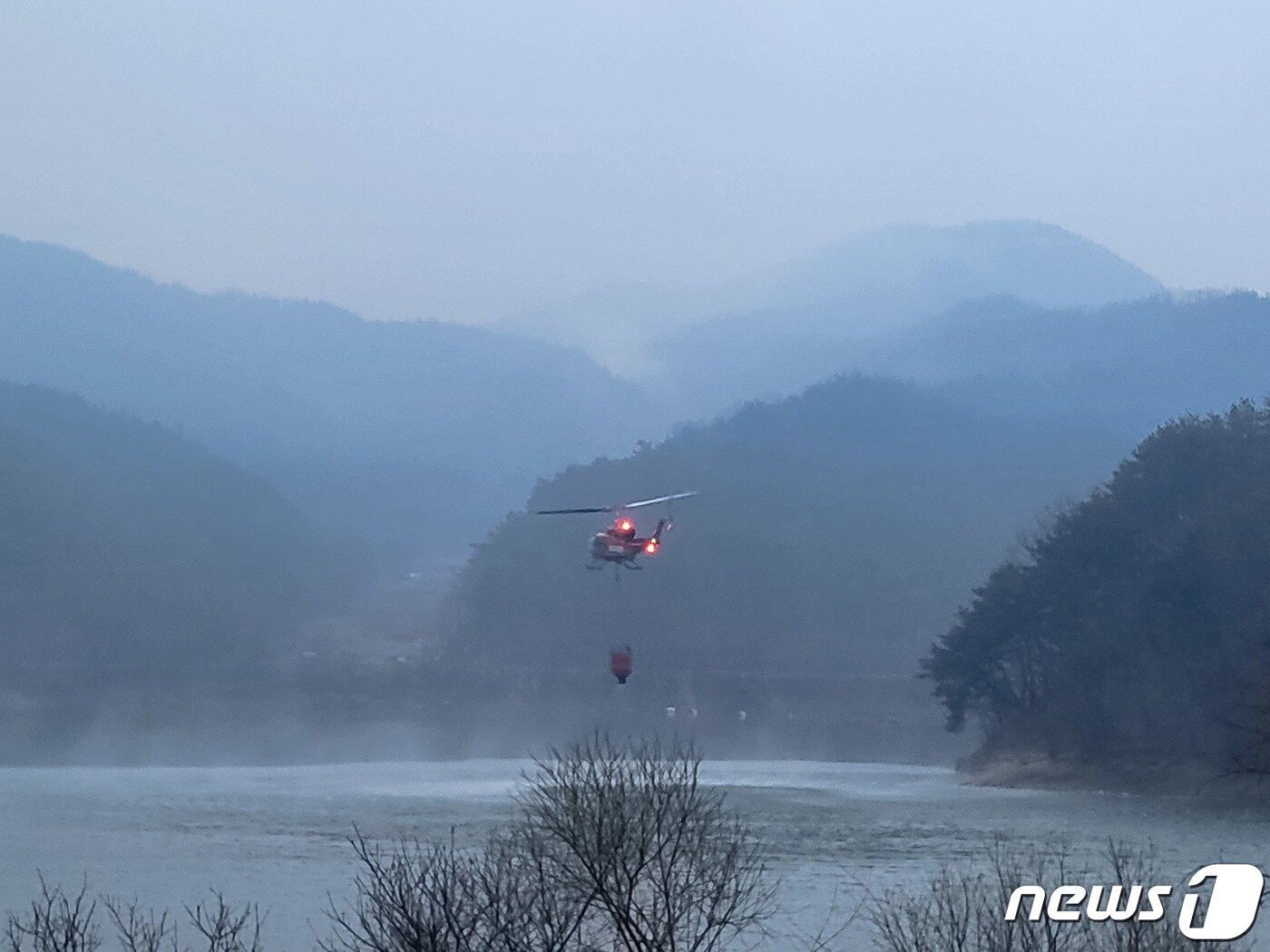 본문 이미지 - 경남 합천군 산불 이틀째인 9일 소방과 산림당국이 날이 밝으면서 헬기 진화를 재개한 가운데 이날 오전 6시50분쯤 합천 한 저수지에서 진화헬기가 물을 담으려 하고 있다. 2023.3.9/뉴스1 ⓒ News1 한송학 기자