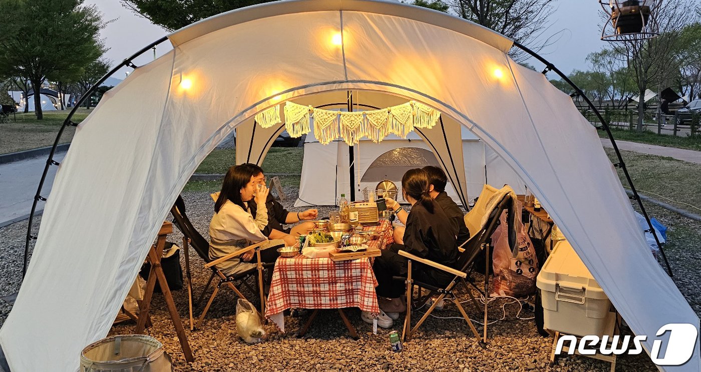 본문 이미지 - 1일 경북 구미낙동강체육공원에서 열린 국내 최대 아웃도어 캠핑축제 '고아웃캠프'에 참여한 캠퍼들이 해가 지자 텐트에 불을 밝히고 멋진 저녁을 보내고 있다. 2023.4.1/뉴스1 ⓒ News1 정우용 기자