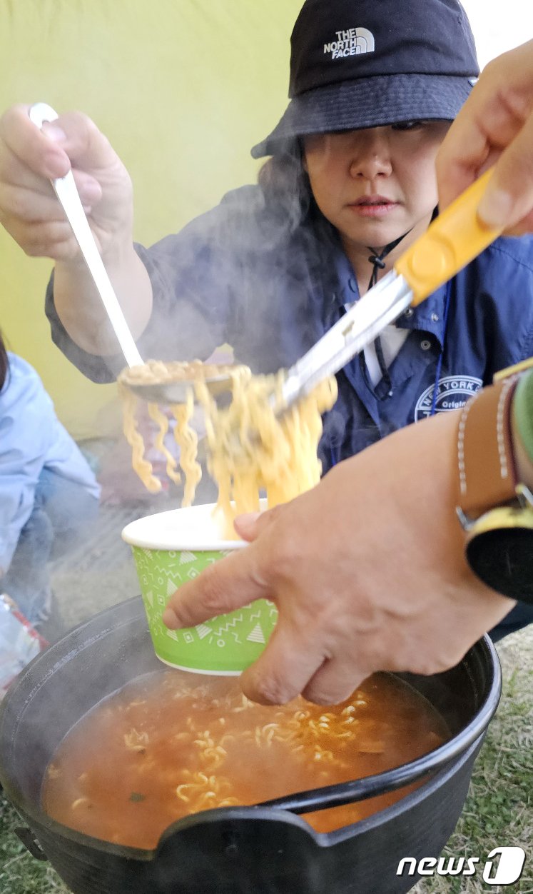 본문 이미지 - 1일 경북 구미낙동강체육공원에서 열린 국내 최대 아웃도어 캠핑축제 '고아웃캠프'에 참여한 캠퍼들이 라면을 끓여 먹고 있다. 2023.4.1/뉴스1 ⓒ News1 정우용 기자