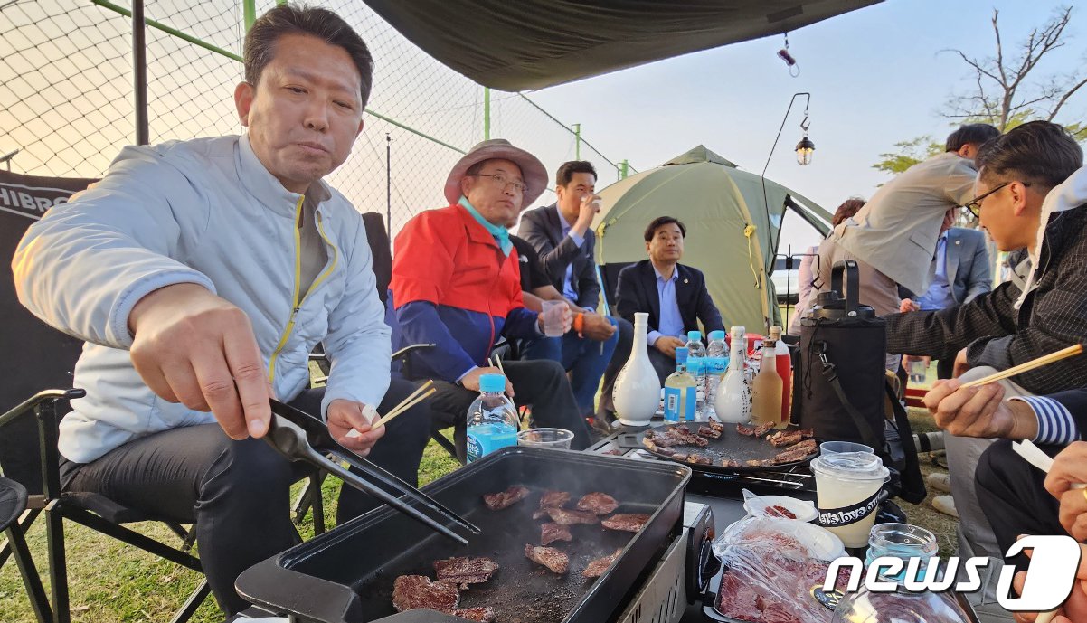 본문 이미지 - 1일 경북 구미낙동강체육공원에서 열린 국내 최대 아웃도어 캠핑축제 '고아웃캠프'장을 방문한 김장호 구미시장(왼쪽 첫번째)이 고아웃캠프 관계자들과 함께 고기를 굽고 있다. 2023.4.1/뉴스1 ⓒ News1 정우용 기자