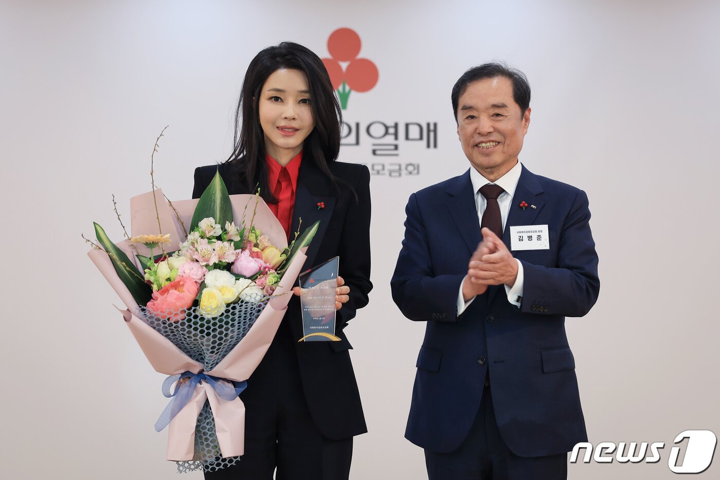 본문 이미지 - 김건희 여사가 11일 서울 중구 사랑의 열매 회관에서 열린 사회복지공동모금회 명예회장 추대식 및 나눔실천 기부자 간담회에 참석해 김병준 회장으로부터 추대패를 전달받은 뒤 기념 촬영하고 있다. (대통령실 제공) 2023.4.11/뉴스1 ⓒ News1 안은나 기자