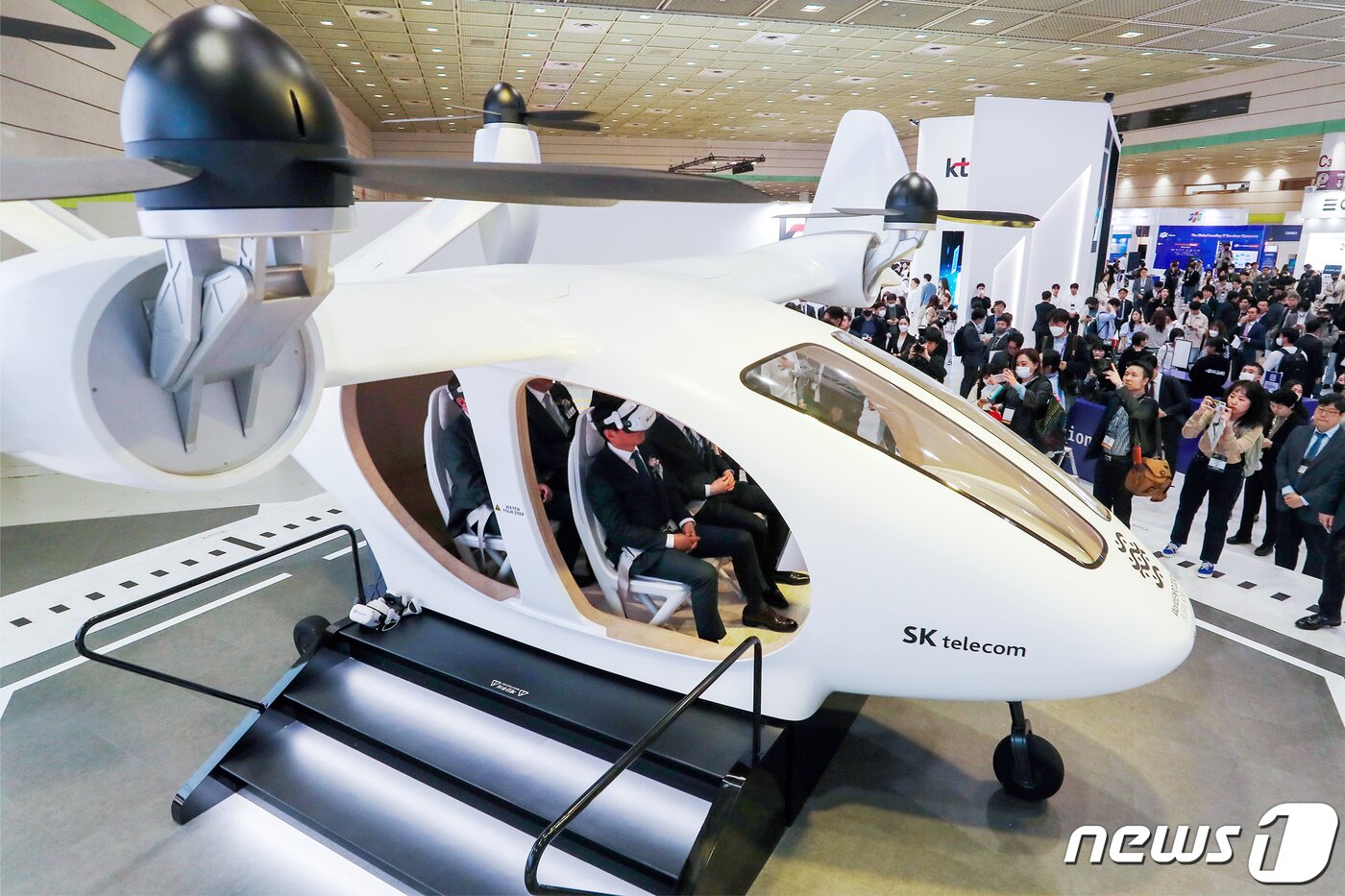 본문 이미지 - 지난 4월 서울 강남구 코엑스에서 열린 '2023 월드IT쇼'를 찾은 관람객들이 SK텔레콤의 도심항공교통(UAM) 체험을 하고 있다. 지2023.4.19/뉴스1 ⓒ News1 민경석 기자