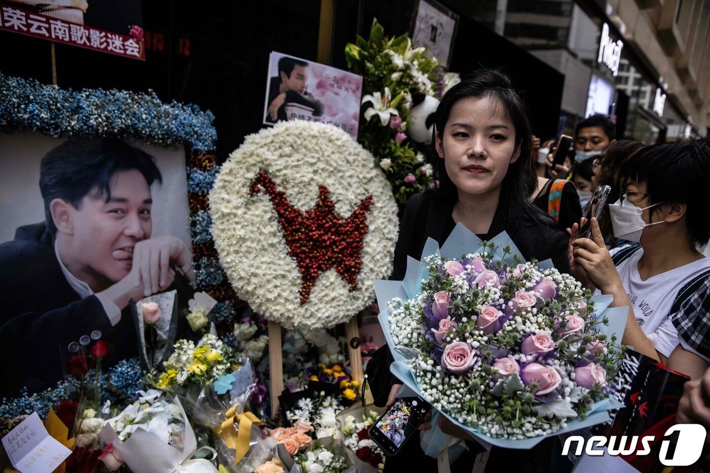 본문 이미지 - 홍콩의 가수 겸 배우였던 장국영 사망 20주기를 맞은 1일(현지시간) 홍콩에서 한 시민이 장국영의 사진 앞에 분홍색 장미 꽃다발을 바치고 있다. 2023.04.01. ⓒ AFP=뉴스1 ⓒ News1 김성식 기자