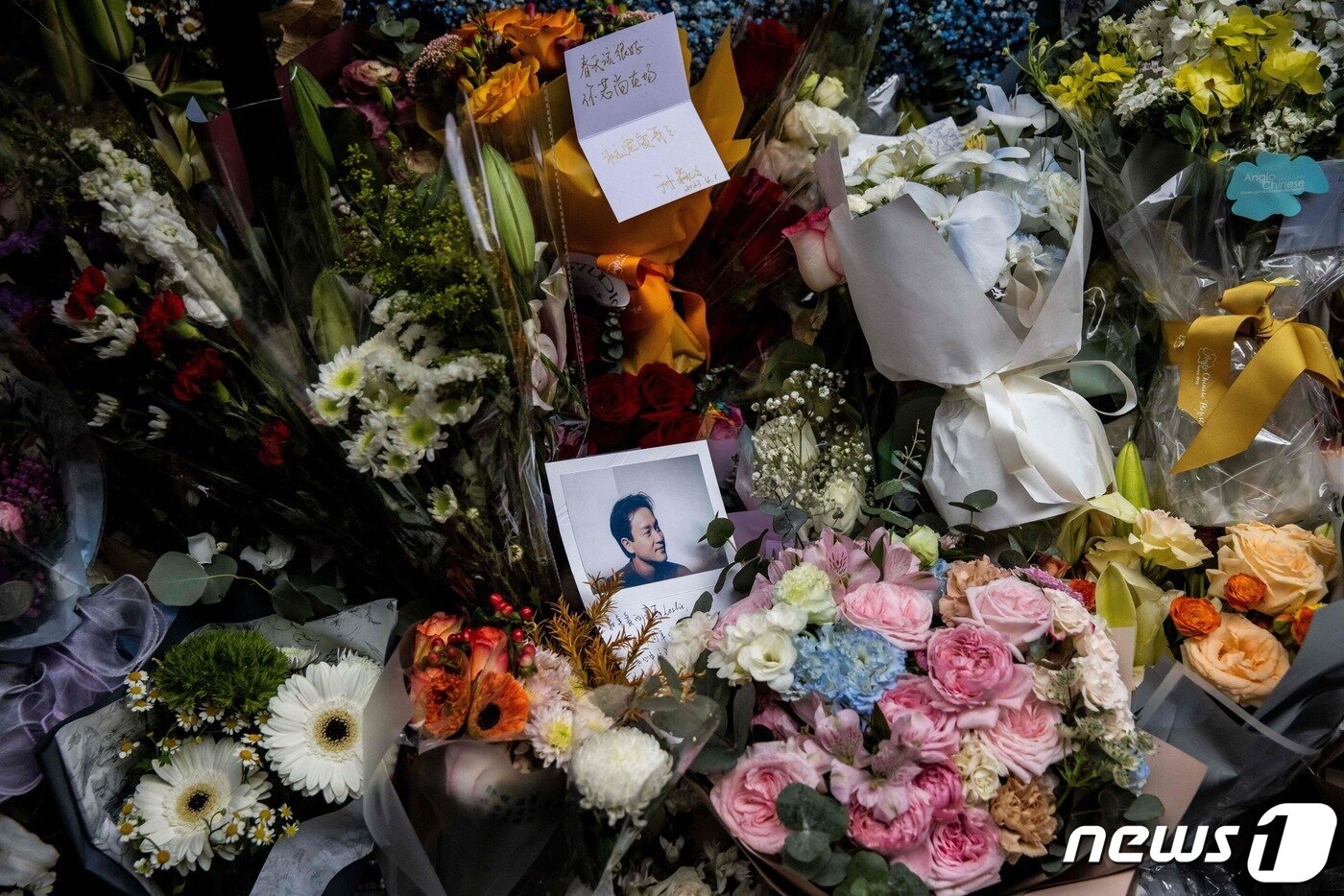 본문 이미지 - 홍콩의 가수 겸 배우였던 장국영의 사망 20주기를 맞은 1일(현지시간) 홍콩의 한 길가에 장국영의 생전 사진과 추모의 꽃다발이 쌓여 있는 모습이다. 2023.04.01. ⓒ AFP=뉴스1 ⓒ News1 김성식 기자