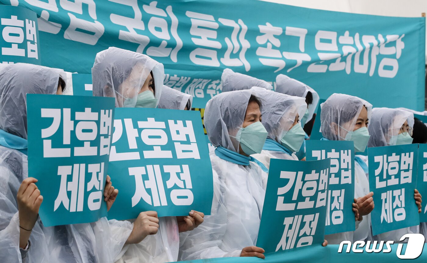 본문 이미지 - 대한간호협회와 시민단체 회원들이 25일 서울 영등포구 국회 앞에서 열린 간호법 국회 통과 촉구 문화마당에서 '간호법 제정'이 적힌 피켓을 들어 보이고 있다. 2023.4.25/뉴스1 ⓒ News1 김도우 기자