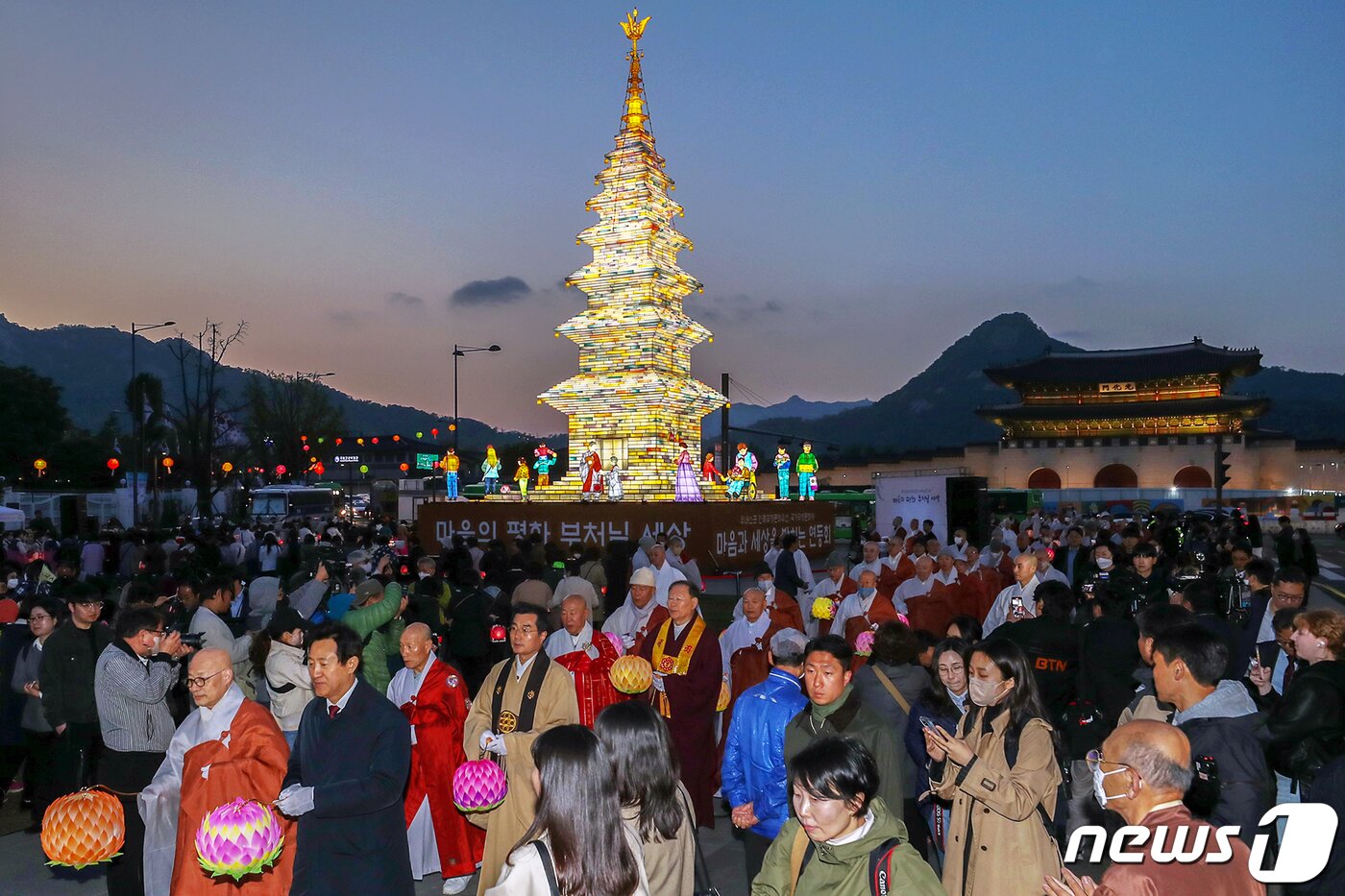 본문 이미지 - 26일 오후 서울 종로구 광화문광장에서 열린 '2023 부처님오신날 봉축점등식'에서 참석자들이 철물 구조와 한지 공예로 만든 높이 20m의 수마노탑 주변 탑돌이를 하고 있다. 2023.4.26/뉴스1 ⓒ News1 민경석 기자